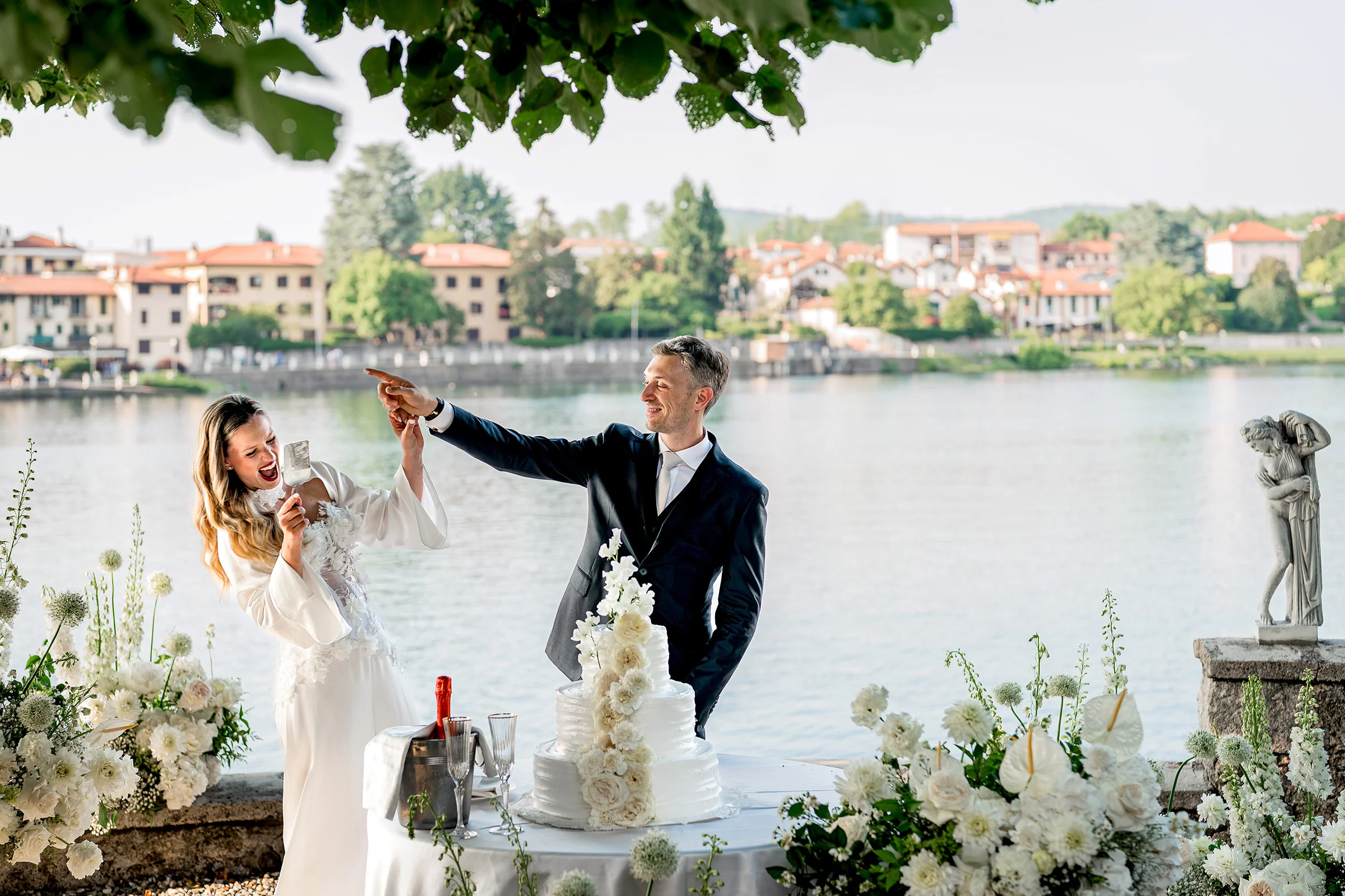Home Page Simone Goglia 8 Bride and groom celebrating the cake cutting by the lake