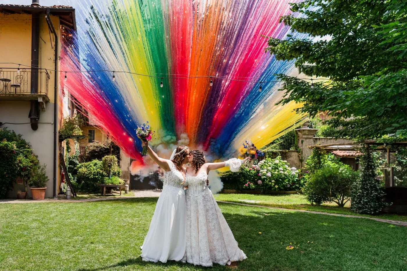 Reviews 3 The brides kiss in the garden in front of a rainbow thread installation