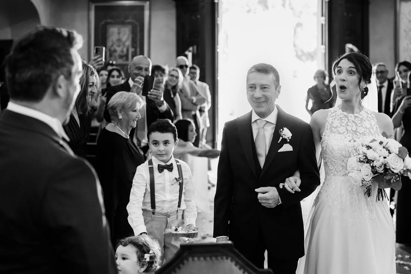 Reviews 8 The bride walks down the aisle on her father’s arm, surprised and moved, in black and white