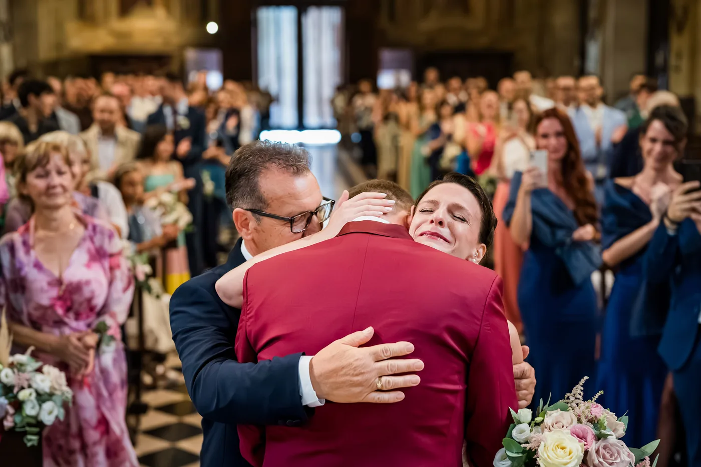 Reviews 10 The bride, in tears, hugs the groom and her father at the altar as guests applaud