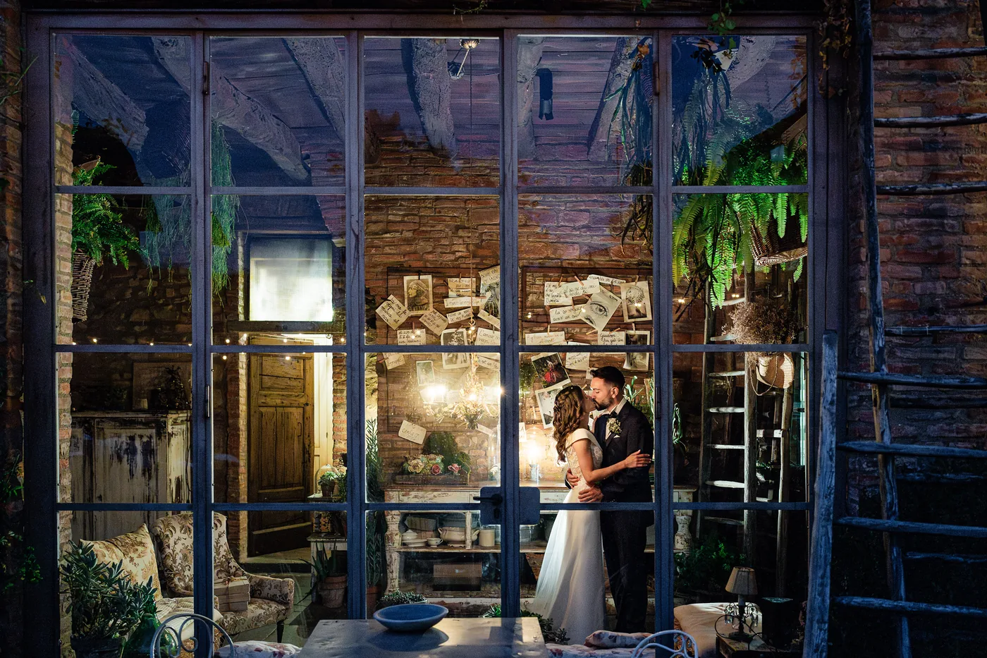 Reviews 6 The couple kiss at night behind a large lit glass window